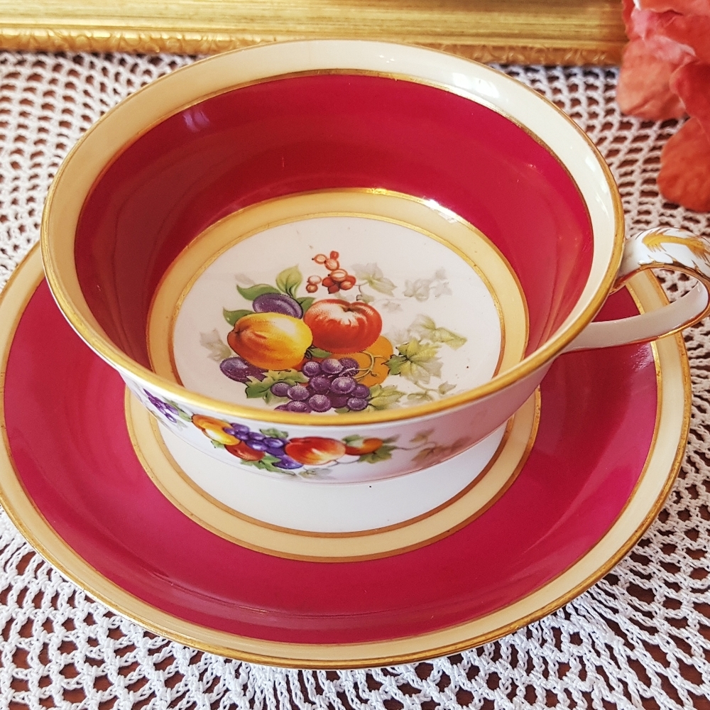 Red and Gold Cup and Saucer with fruit designs.